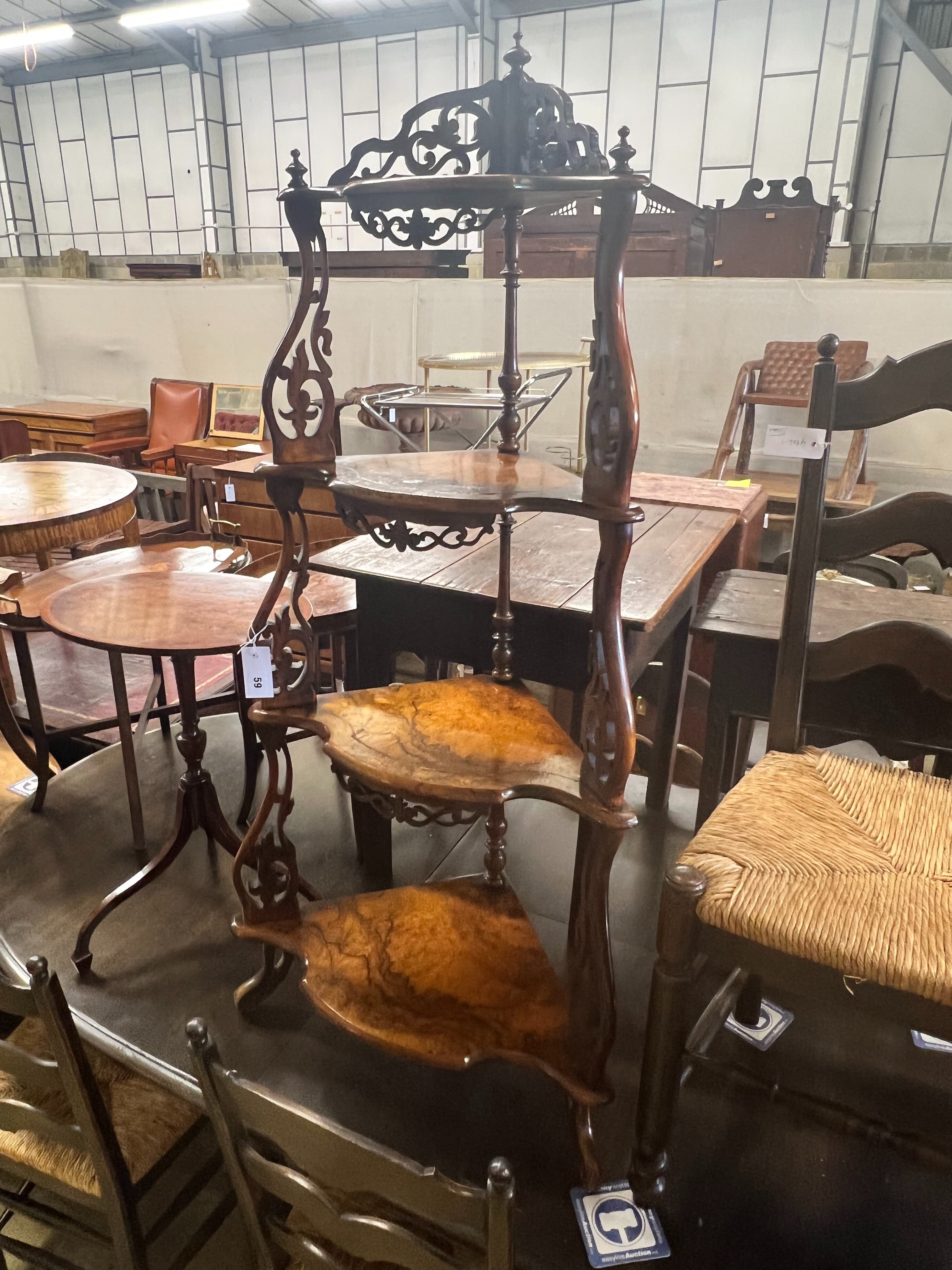 A Victorian figured walnut four tier corner whatnot, with graduated bowfront shelves and foliate scroll supports, width 59cm depth 37cm height 126cm